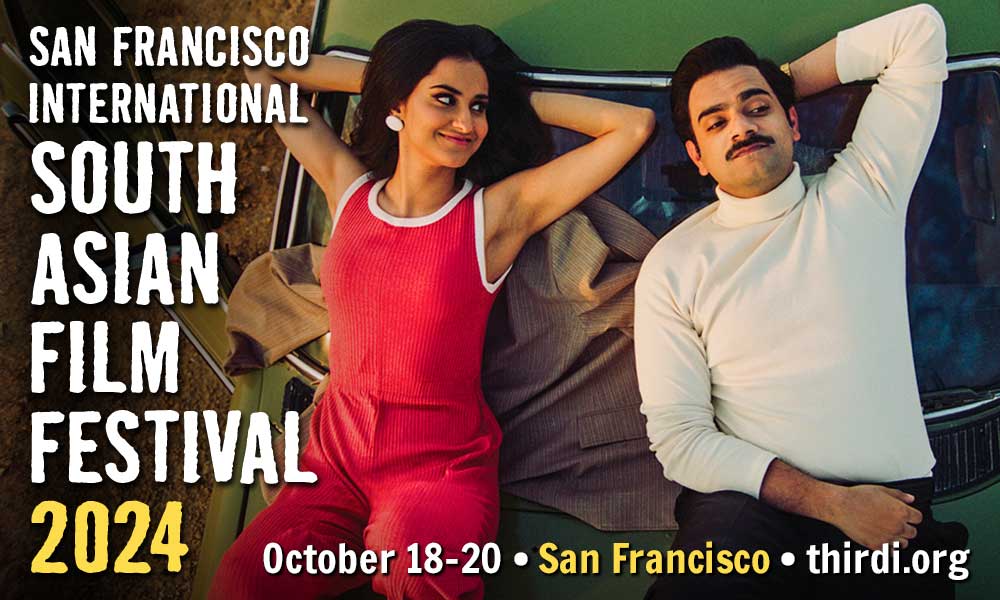 A young man and woman, seen from above, lean on the hood of a car. The woman looks at the man with a mischievous expression. The lighting is amber, and the car is a muted green, giving the image a vintage quality. Sill from the film, "The Queen of My Dreams." Text reads: San Francisco International South Asian FIlm Festival, October 18-20, San Francisco"